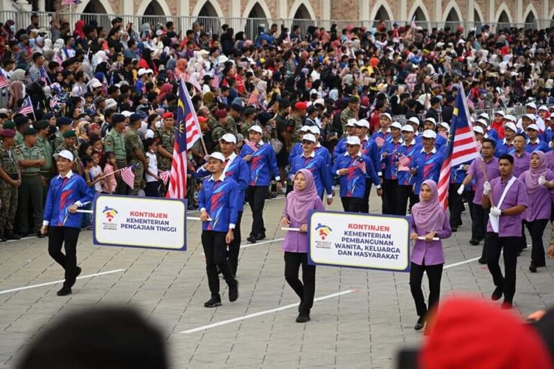 Kontinjen KPT (kiri) gagah mengatur langkah dalam perbarisan sempena sambutan Hari Kebangsaan 2022 di Dataran Merdeka